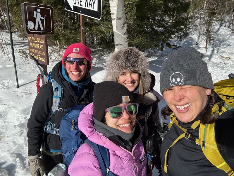 photo of the four of us in front of the trailhead sign
